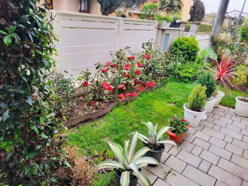 a garden with potted plants and a white fence at New Bedrooms Mamma Gigetta in Noventa di Piave