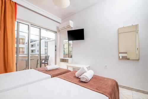 two beds in a hotel room with a tv at City Life Marina apartment No.24 in Ampavris