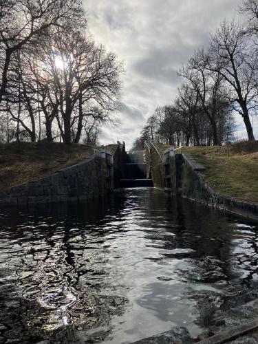 a small dam on a river with trees in the background at Stationshus apartment in Hallstahammar