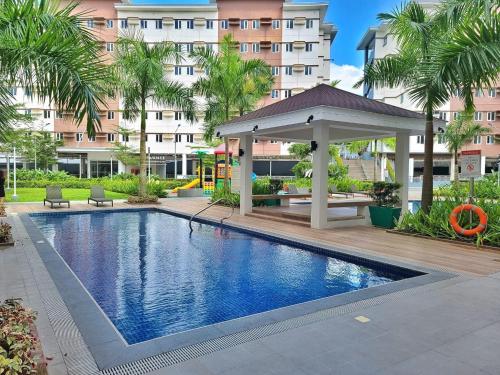 a swimming pool with a gazebo next to a building at Casa Del Perucho in Trece Martires