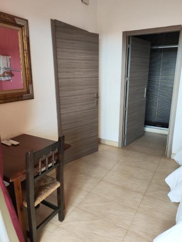 a room with a wooden door and a table and chair at L'Olivera Casa Rural in Castellbisbal