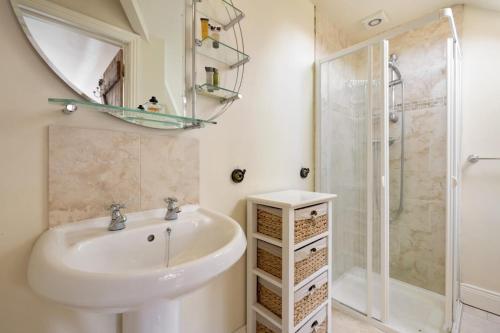 a bathroom with a sink and a shower at Cherrygarth Cottage in White Hall
