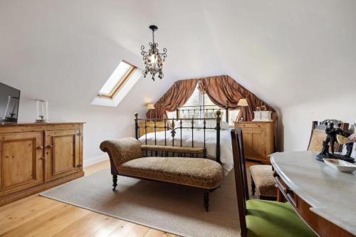 a bedroom with a bed with a chair and a chandelier at Cherrygarth Cottage in White Hall