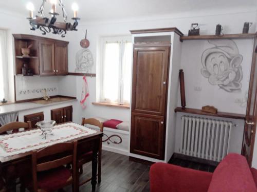 eine Küche mit einem Tisch und einem Esszimmer in der Unterkunft La tana di Pisolo in Vicoforte
