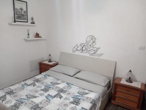 Schlafzimmer mit einem Bett mit Wandzeichnung in der Unterkunft La tana di Pisolo in Vicoforte