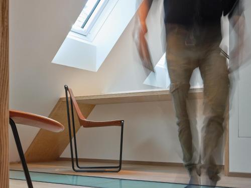 a person walking up a stair case with a window at Haus Fünf mit 2 Apartments und Studio-Loft mit Terrasse in Melk