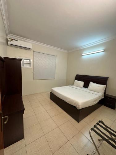 a bedroom with a bed in a room with a projector at الديوان النجدي للشقق المخدومة اقتصادي in Ukaz