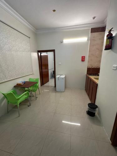 a room with a table and green chairs in a room at الديوان النجدي للشقق المخدومة اقتصادي in Ukaz