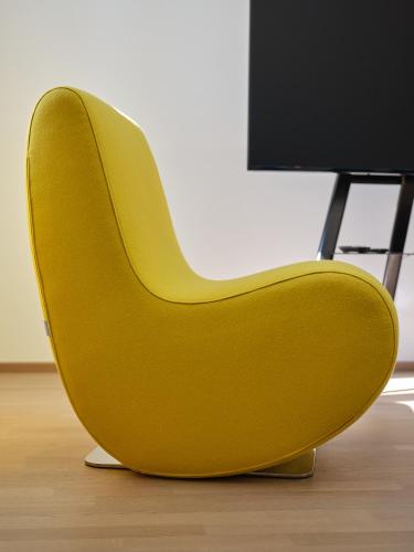 a yellow chair sitting in front of a computer monitor at Haus Fünf mit 2 Apartments und Studio-Loft mit Terrasse in Melk