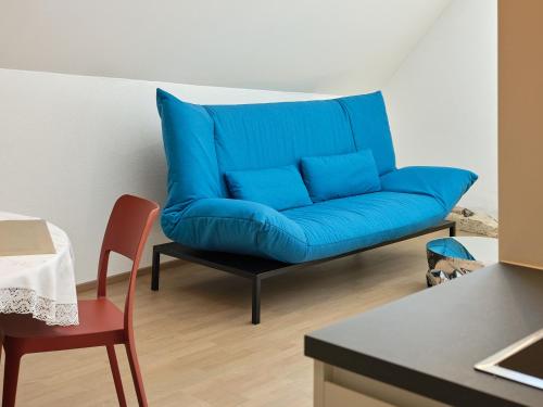 a blue couch in a living room with a table at Haus Fünf mit 2 Apartments und Studio-Loft mit Terrasse in Melk