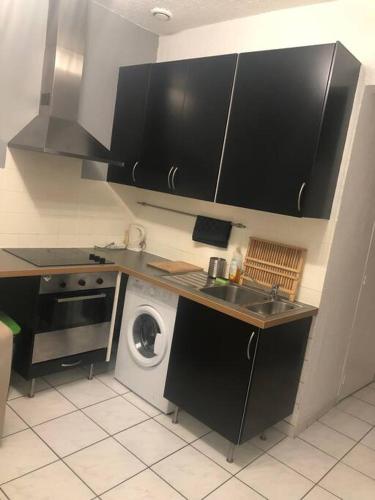 une cuisine avec un évier et une machine à laver dans l'établissement « Le petit Bastille»Proche Lyon centre, à Villeurbanne