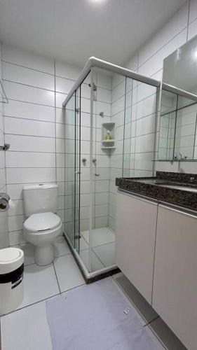 a bathroom with a toilet and a glass shower at Flat Villa Monte Castelo in Bezerros