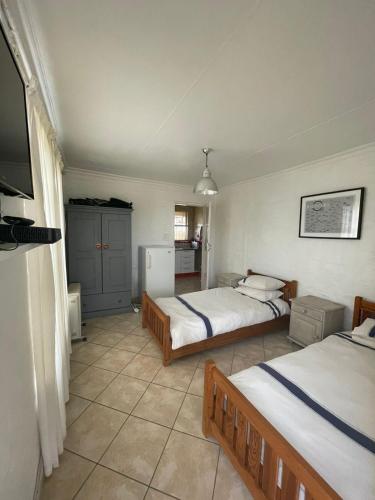 a bedroom with two beds and a tv in it at Holiday Flat at Vaaldam Sgt Pepper's in Oranjeville