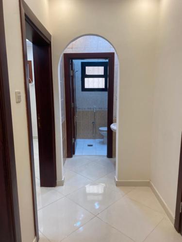 a hallway with a bathroom with a toilet and a mirror at شقق ضيافة رغد 2 in Al Madinah
