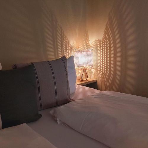 a bedroom with a bed with white sheets and a lamp at Bed and Breakfast Wehlen in Stadt Wehlen
