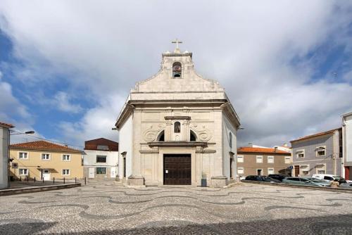 a large white building with a cross on top at São Roque Sweet Burgo in Aveiro