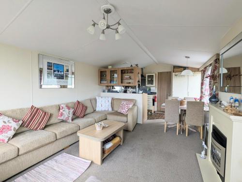a living room with a couch and a table at Peacehaven, Ynyslas, Borth in Borth