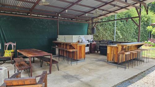 an outdoor kitchen with wooden tables and a grill at Bamboo River House and Hotel in Dominical