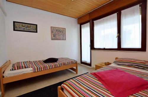 1 Schlafzimmer mit 2 Betten und 2 Fenstern in der Unterkunft Apartment Marina in Petrcane