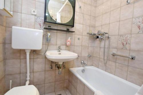 ein Badezimmer mit einem WC, einem Waschbecken und einer Badewanne in der Unterkunft Apartment Marina in Petrcane