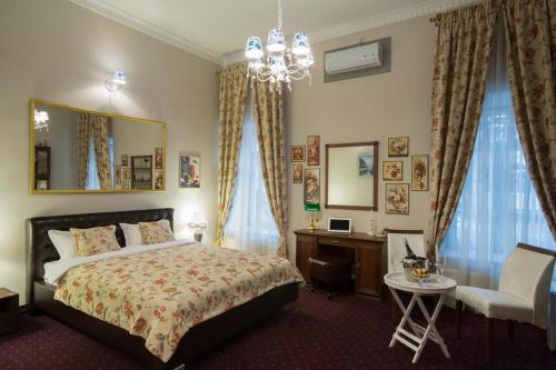 a bedroom with a bed and a desk and a chandelier at Vila Elat in Chişinău