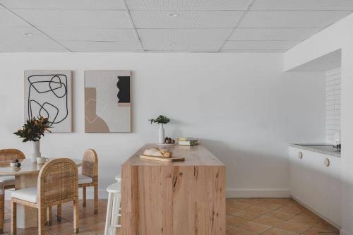 a kitchen with a wooden table and chairs and a table at The Ace - Byron Bay in Byron Bay