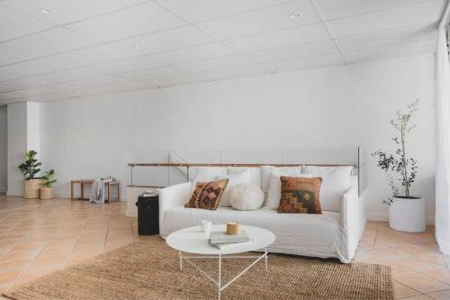 a living room with a white couch and a table at The Ace - Byron Bay in Byron Bay