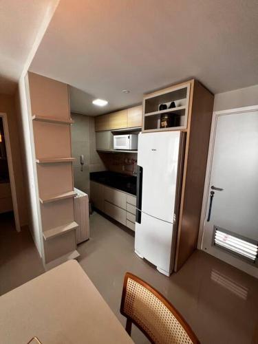 een kleine keuken met een witte koelkast en planken bij Flat completo e aconchegante in Recife