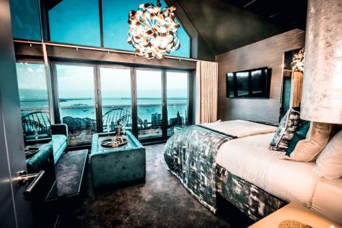 a bedroom with a large bed and a chandelier at Highlights Views, Overlooking Mouth of the Tyne in Tynemouth