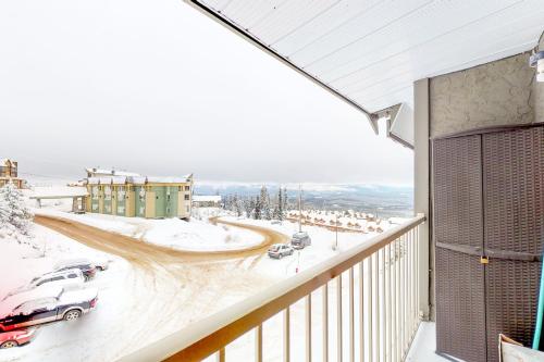 a balcony with a view of a snow covered street at Snow Ghost Inn 326 in Big White