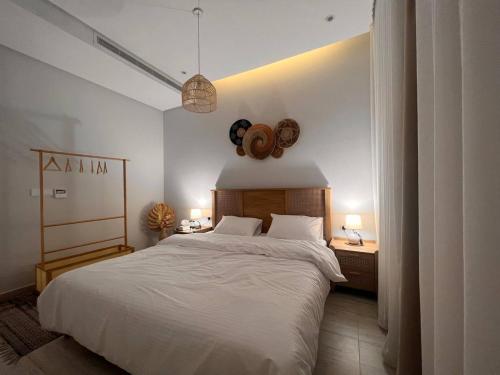 Zaya luxury apartment في الرياض: غرفة نوم بسرير ابيض كبير ومصباحين