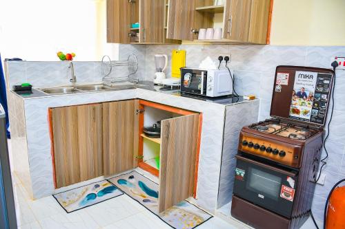 a small kitchen with a refrigerator and a stove at Raven Suites in Kakamega