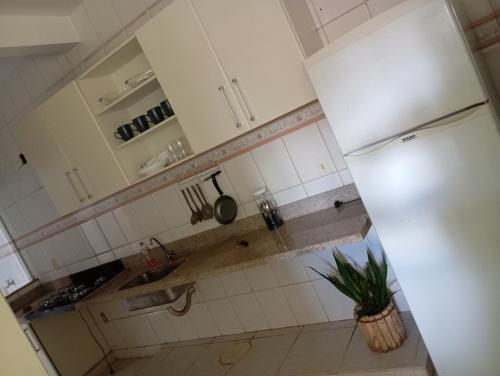 a kitchen with white cabinets and a white refrigerator at Apartamento por temporadas in Rio Verde