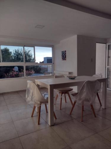 een eetkamer met een tafel, stoelen en ramen bij Casa Tulia in Tolosa