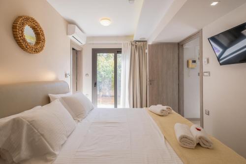 een slaapkamer met een groot wit bed en handdoeken bij Glaros Casa Verde - Cozy flat with Garden near Beach in Kato Daratso
