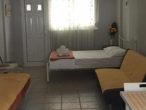 a small bedroom with a bed and a chair at nastro azzurro sole in Kallithea Halkidikis