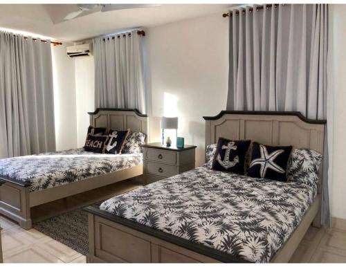 una camera con due letti e un comodino di Casa Carey Lajas Pty Exclusive Beachfront Villa a Cabrera