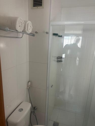 a white bathroom with a shower and a toilet at Suíte com sacada Hotel Mercure in Nova Iguaçu