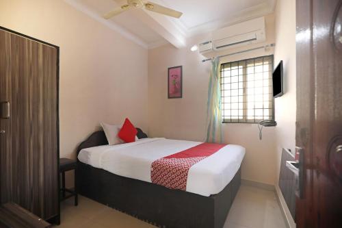 a small bedroom with a bed and a window at OYO Athithi Comforts in Bangalore