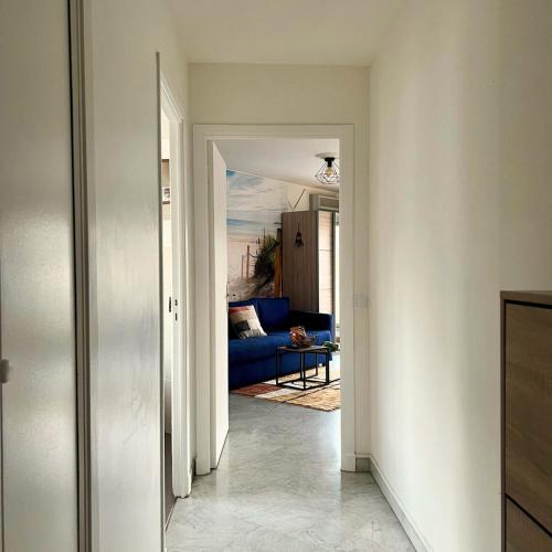 un couloir menant à un salon avec un canapé bleu dans l'établissement Cozy Studio Near Promenade, à Nice