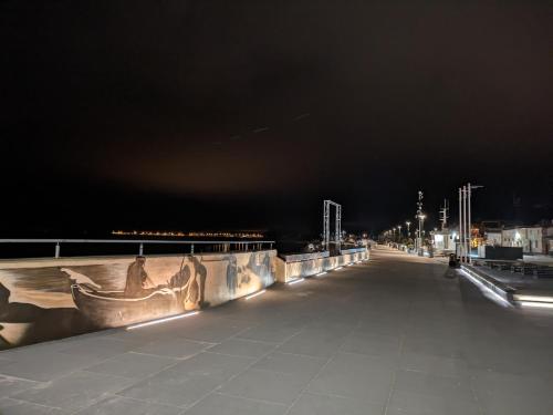 un paseo marítimo por la noche con luces en un puente en Deep Blue - Apartament Hel, en Hel