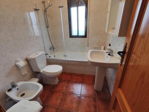 a bathroom with a toilet and a sink and a tub at VFT DOÑA ELVIRA SIERRA in Virgen de la Cabeza