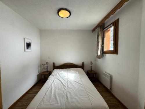- une chambre dotée d'un lit avec un drap blanc dans l'établissement Résidence Les Hauts De Preclaux - Appartement 2 pièces au pied des pistes MAE-8031, aux Orres
