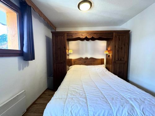 une chambre avec un lit avec une tête de lit en bois dans l'établissement Résidence Les Hauts De Preclaux - Appartement au coeur des Orres 1800 MAE-8051, aux Orres