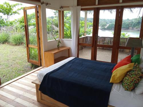 a bedroom with a bed and a balcony with windows at Infinity-house with direct access to the beach in Santana