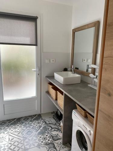 uma casa de banho com um lavatório e uma máquina de lavar roupa em T2 Dans le vent Gruissan bord de mer em Gruissan