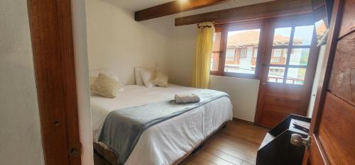 a bedroom with a white bed and a window at Hotel Villa Javier VDL in Villa de Leyva