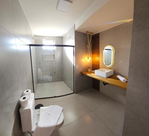 La salle de bains est pourvue d'une douche, de toilettes et d'un miroir. dans l'établissement Pousada Alkamar Quarto comfort, à Maragogi
