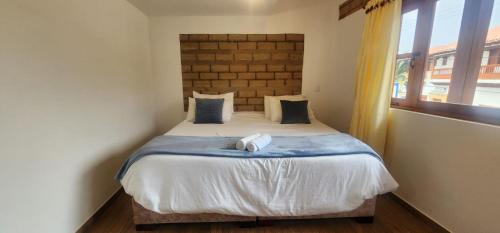 a bedroom with a bed with a large window at Hotel Villa Javier VDL in Villa de Leyva