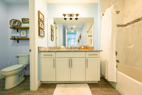 a bathroom with a sink and a toilet and a mirror at Bungalow at Margaritaville! Less than 1 Mile to AMI! in Bradenton